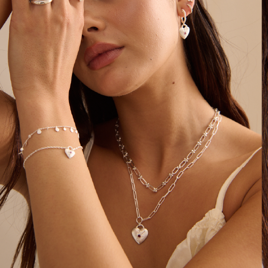 Woman wearing silver jewelry including a necklace, bracelet, and earrings.