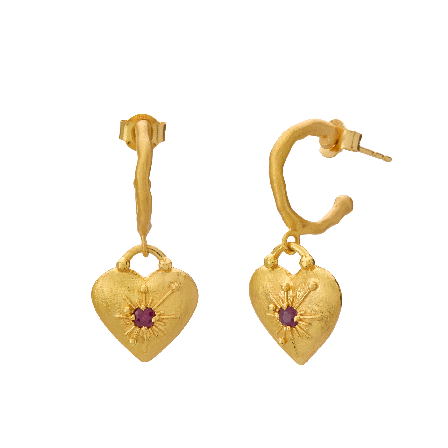 Gold heart-shaped earrings with a central red gemstone on a white background