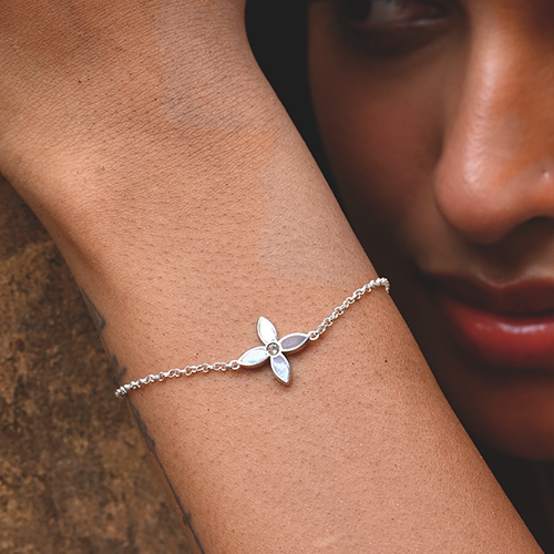 Silver bracelet with a leaf design on a person's wrist.
