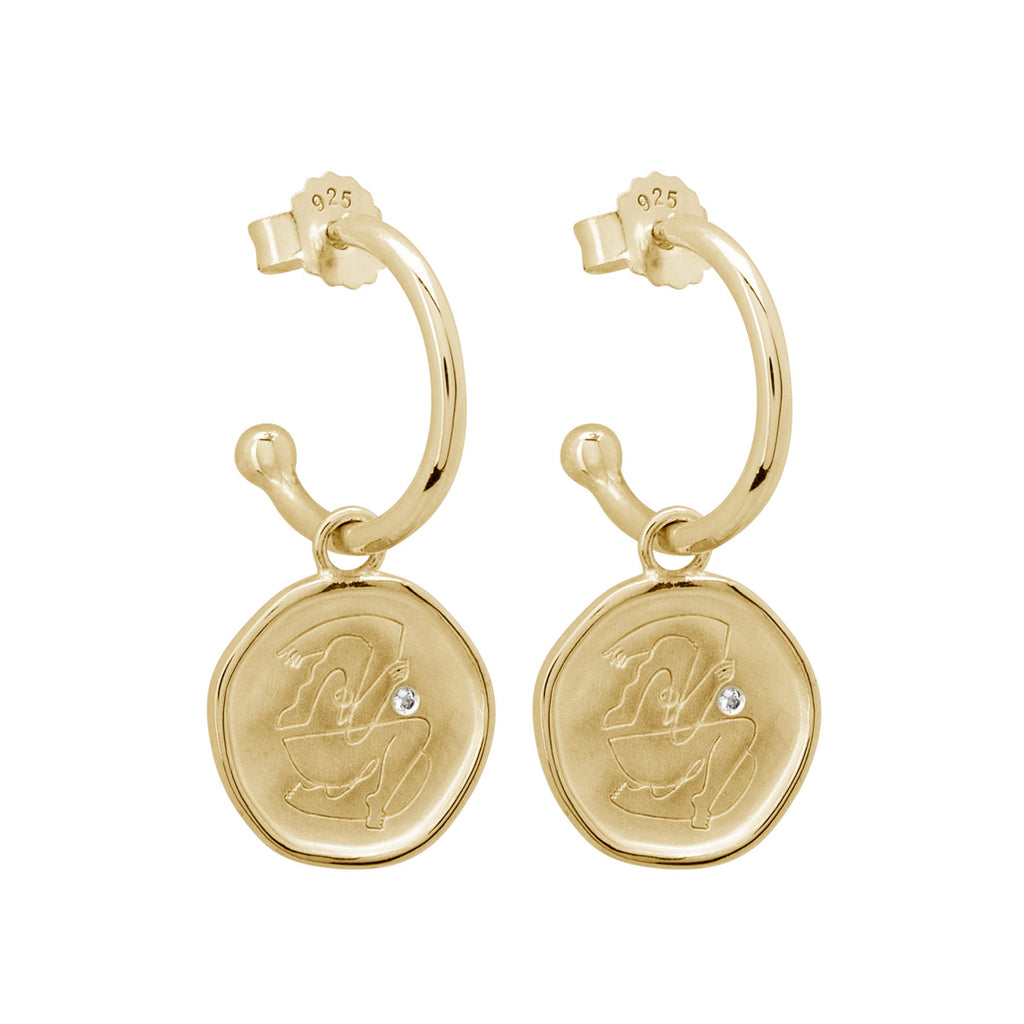 Gold empowerment hoop earrings, handcrafted by an artisan, showcasing intricate craftsmanship and attention to detail.
