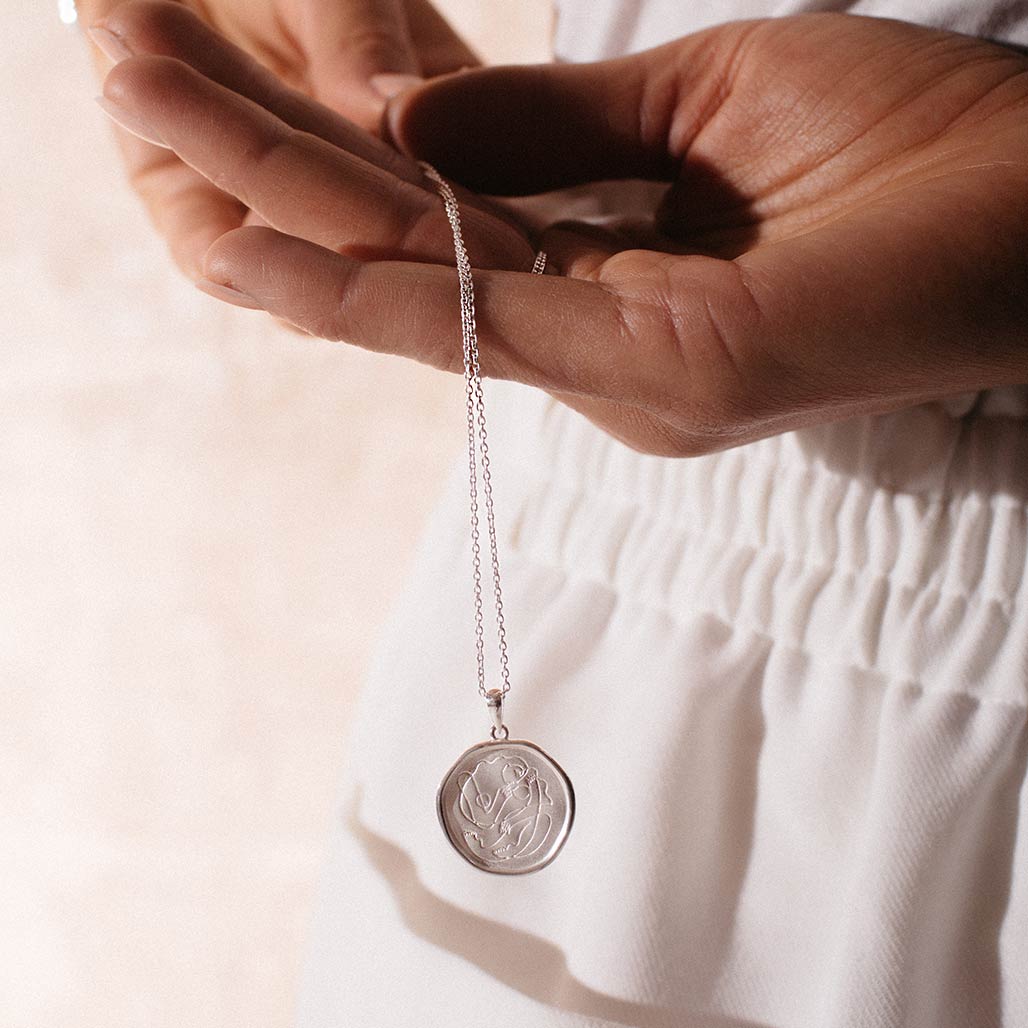 Handcrafted Sterling Silver necklace celebrates the bond between mother and child. Artisan-made and intricately designed.