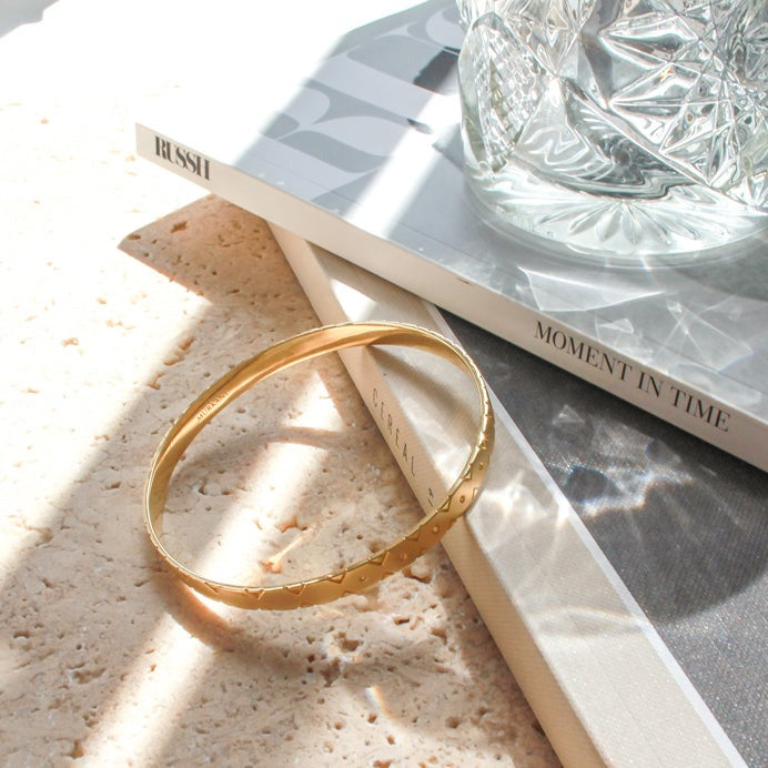 Modern gold bangle with Celtic symbolism, perfect for stacking and making a statement. Inspired by ancient symbolism.