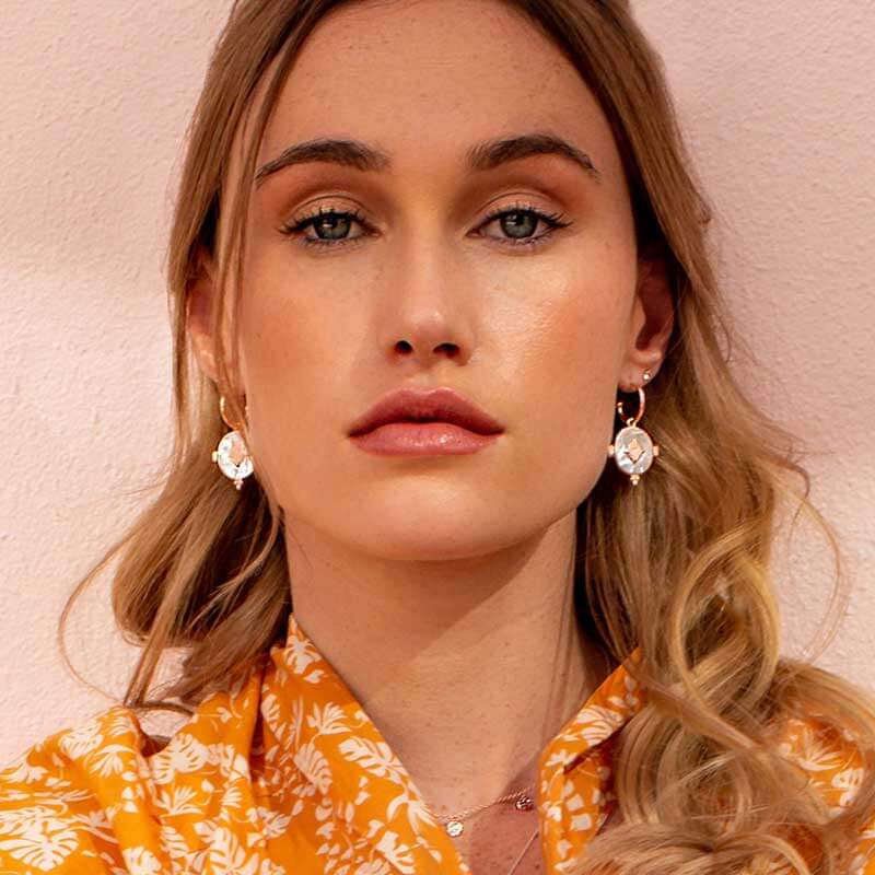 Handcrafted hoop earrings featuring luminous mother of pearl pendant. Crafted by skilled artisans.