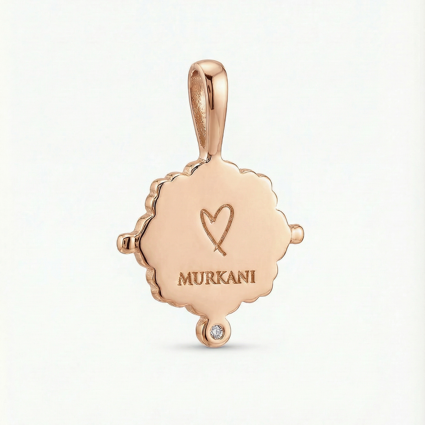 Rose gold pendant with 'MURKANI' engraving on a light gray background