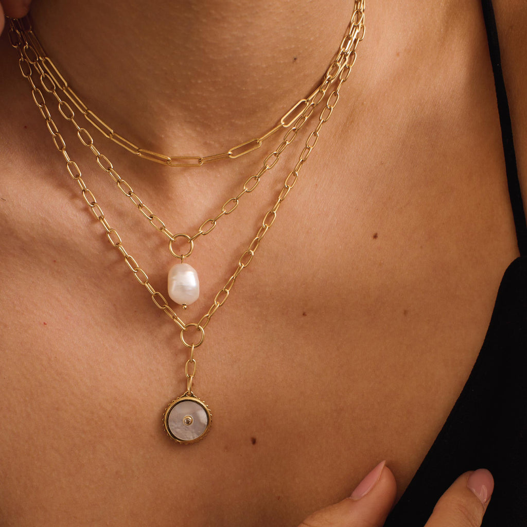 Ethically made artisan gold drop necklace featuring ancient symbolism for courage and strength. 