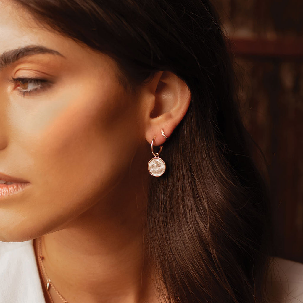 Rose Gold empowerment hoop earrings, handcrafted by an artisan, showcasing intricate craftsmanship and attention to detail.