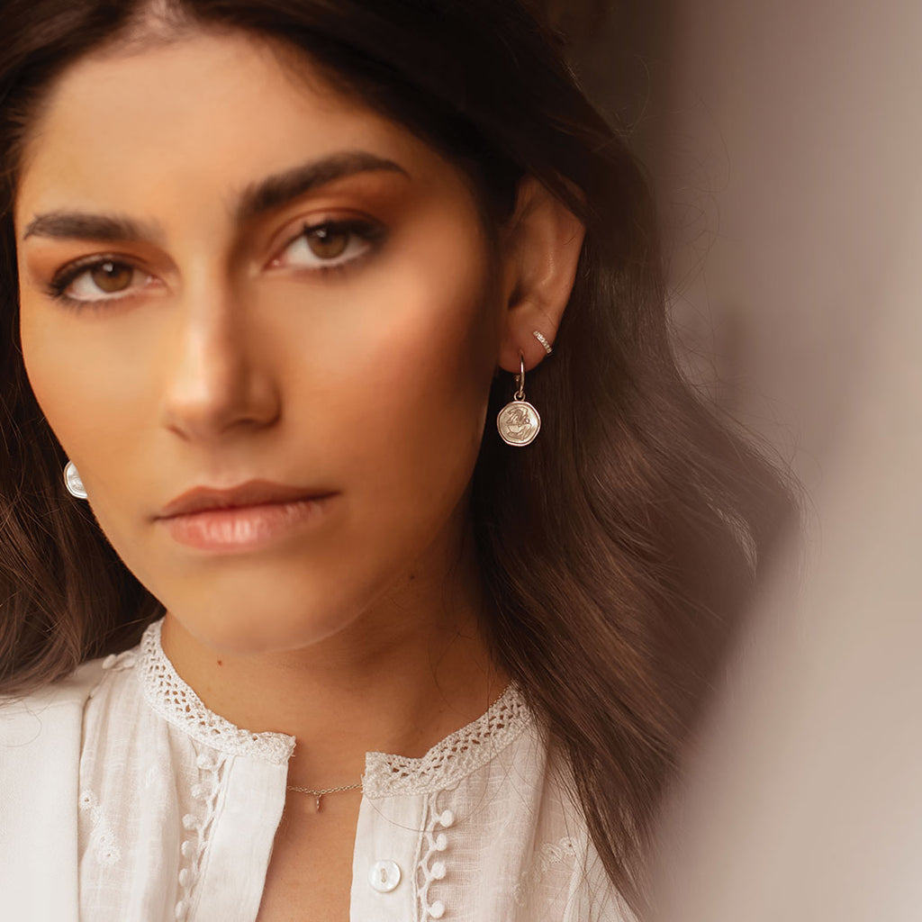 Sterling Silver empowerment hoop earrings, handcrafted by an artisan, showcasing intricate craftsmanship and attention to detail.
