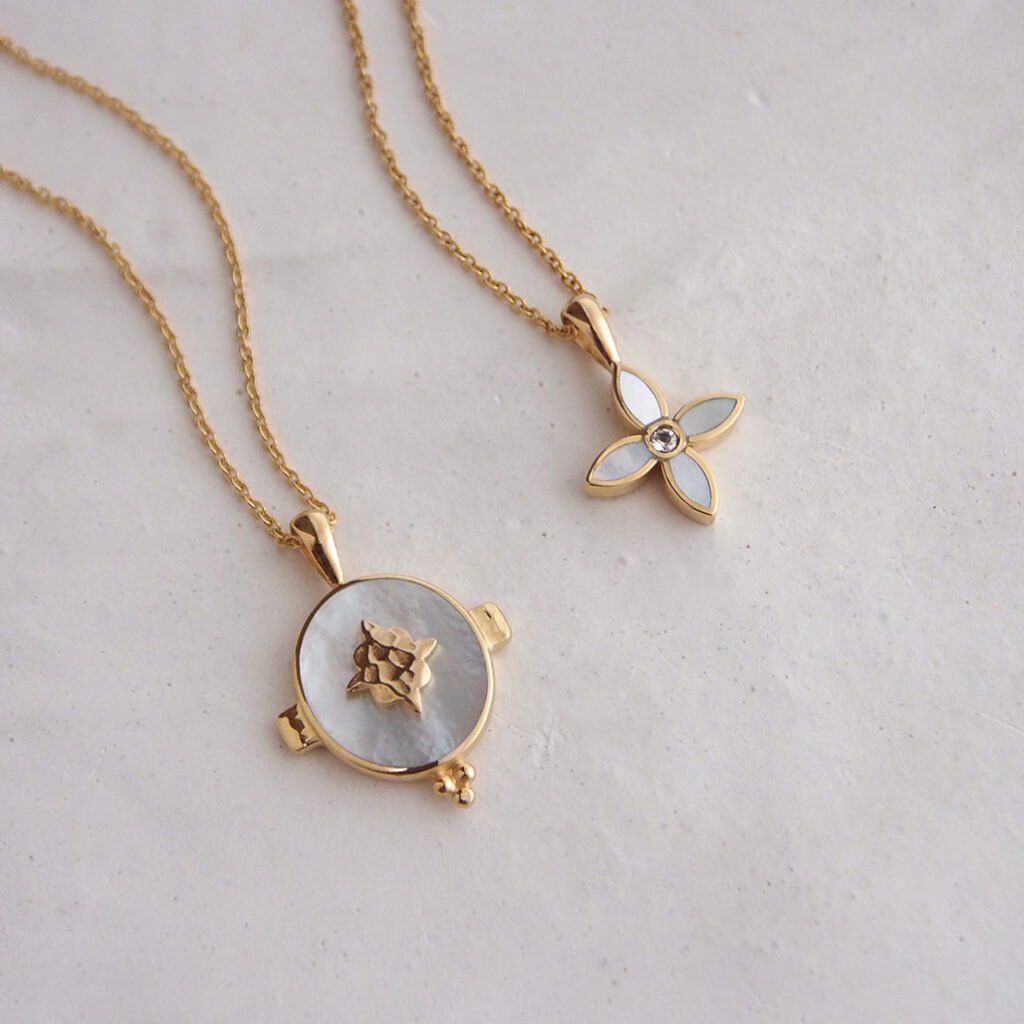 A handcrafted necklace featuring a mother of pearl pendant in a yellow gold setting. An Artisan-made piece of jewellery.