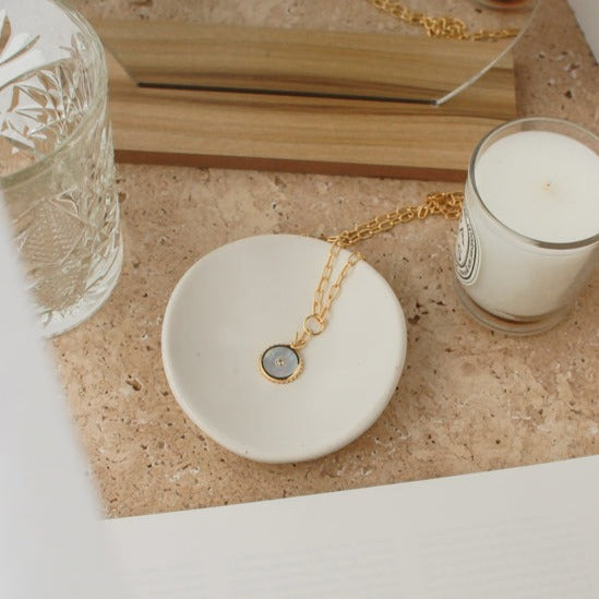 Ethically made artisan gold drop necklace featuring ancient symbolism for courage and strength. 