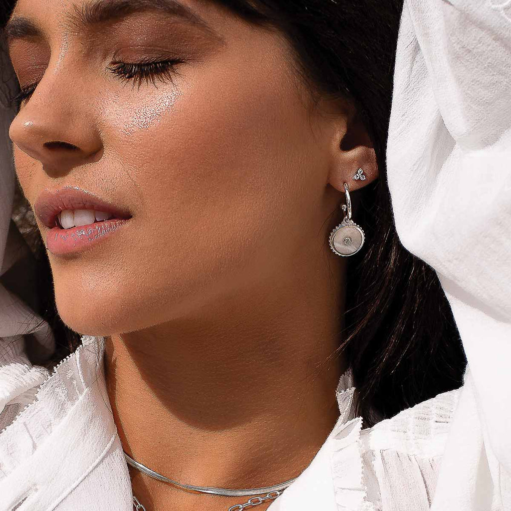 Sterling silver hoop earrings with moonstone, white topaz, and Ailm cross design symbolising fearlessness. 