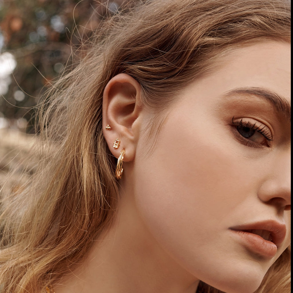 Ethically made, handcrafted gold hoops with a modern, textural design. Artisanal production and artisan-made.